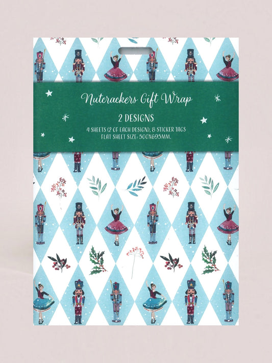 A packaged holiday gift wrap set labeled 'Nutackers Gift Wrap' with two designs. The visible wrap pattern shows a light blue and white harlequin diamond design with nutcracker figures, ballerinas, birds, and small floral motifs.